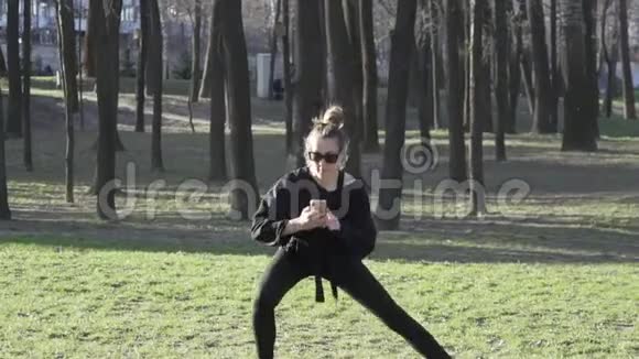 年轻女性在公园健身训练前锻炼健康的年轻女性在户外热身被分散注意力视频的预览图