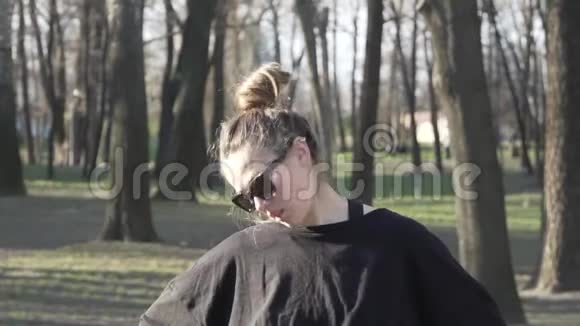 健身运动训练公园和生活方式的概念女人伸展脖子户外有魅力的年轻女人在热身视频的预览图