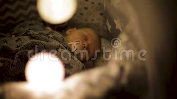 新生儿睡在婴儿床上嘴里放着奶嘴舒适的儿童床视频的预览图