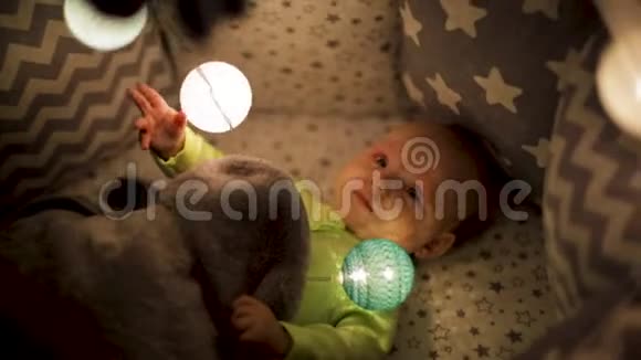 幼儿在床上活动手持相机抖动一个刚出生的婴儿玩灯光视频的预览图
