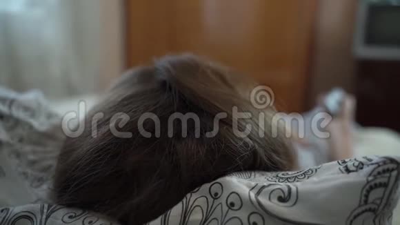 女孩躺在一个小房间的床上看着一台小电视视频的预览图