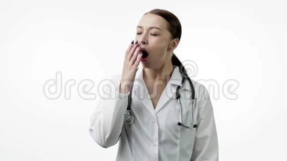 疲倦的医生打哈欠戴上便携的颈枕打盹或打盹闭上眼睛视频的预览图