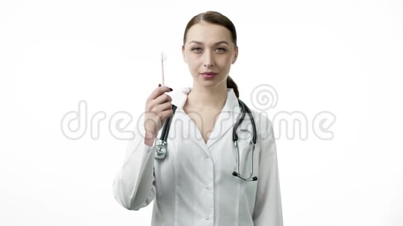 微笑性感的医生拿着牙刷像拇指上的手势视频的预览图