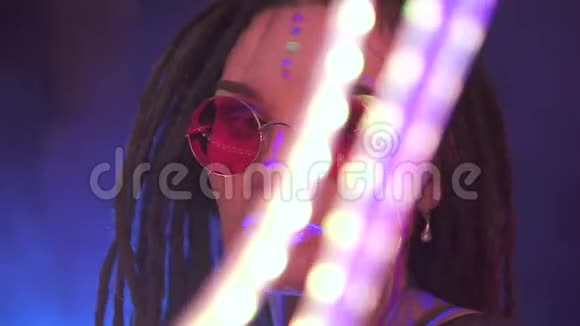 一个女孩的可怕的肖像在霓虹灯uf光女模特带着一个带着铅笔跳舞是红色太阳镜艺术设计视频的预览图