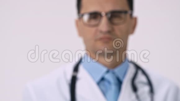 严肃的医生拿着透明的罐子和绿色药丸把它们洒下来视频的预览图