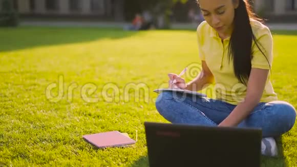 有目的的学生坐在公园里不停地学习4K视频的预览图