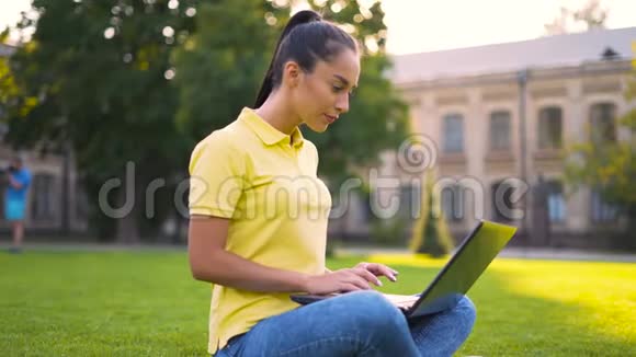 穿黄色T恤的女人在电脑上工作视频的预览图