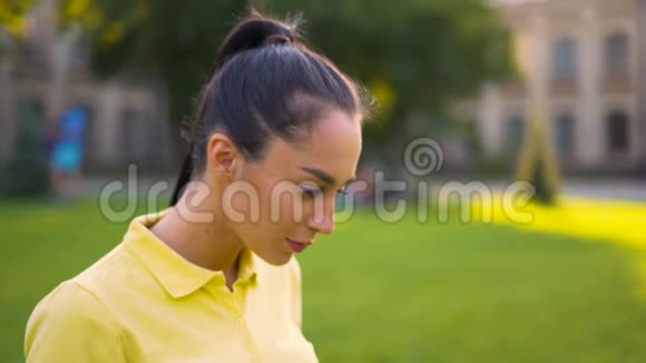 肖像特写穿黄色T恤的女人在电脑上工作视频的预览图