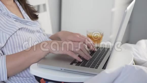 一个女人在家里的电脑里工作在床上视频的预览图