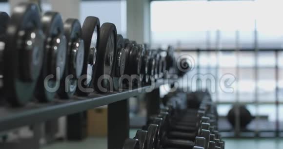 在健身房举重的女人手臂提升重量的细节健身中心女子训练健身女孩视频的预览图