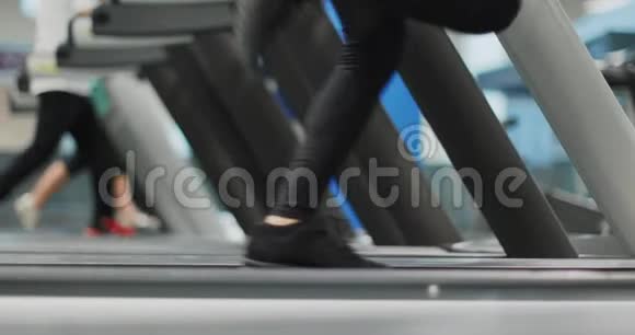 年轻女子在健身房跑步机上跑步侧视腿部细节健身中心女子训练妇女行使权力视频的预览图