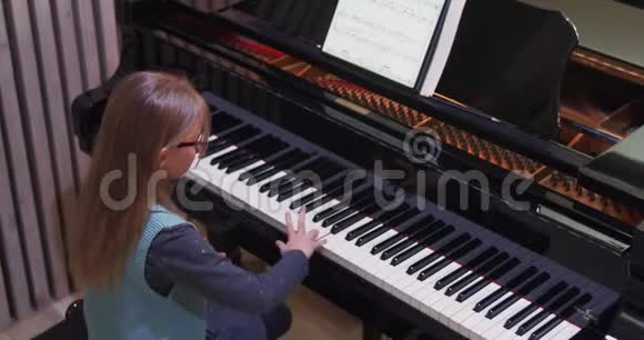 孩子在家学弹钢琴孩子练钢琴侧视小女孩弹钢琴视频的预览图