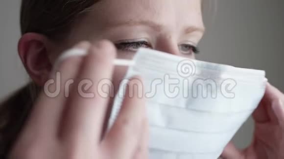 戴上医用口罩PPE遮住鼻子和嘴的慢动作视频的预览图