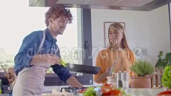 两人在家做饭准备饭菜年轻夫妇在家做饭准备午餐男人和女人一起做饭视频的预览图
