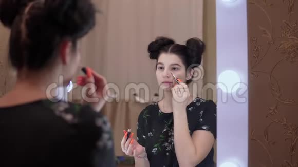 女孩把遮瑕膏放在镜子里用于视觉美容博客的概念视频的预览图