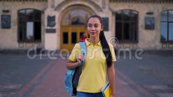 追踪摄像头学生离开大学年轻女孩平静地走在公园里视频的预览图