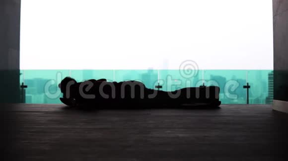 一位年轻人在大都市剪影背景下的晨练体操视频的预览图