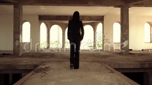 面目全非的黑发女郎走在被遗弃的大楼里视频的预览图