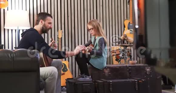 爸爸给女儿教吉他和四弦琴小女孩在家学吉他侧视在家上Ukulele课视频的预览图