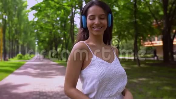 户外带耳机的开朗女性视频的预览图
