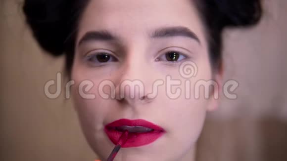 年轻女子涂红口红化妆美容博主视频的预览图