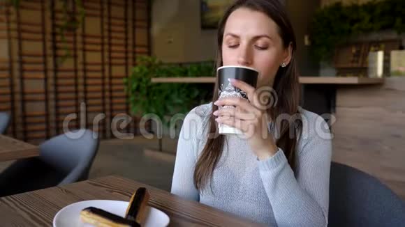 女人在咖啡馆里吃巧克力蛋糕喝咖啡视频的预览图