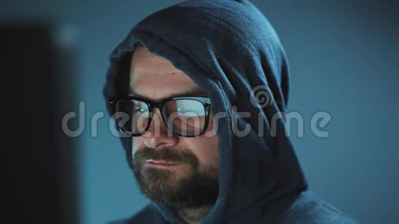 戴着头巾的男黑客和戴着眼镜在黑暗的办公室里用电脑工作网络犯罪概念视频的预览图