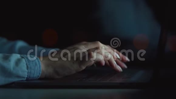 女人的手在晚上用笔记本电脑打字视频的预览图