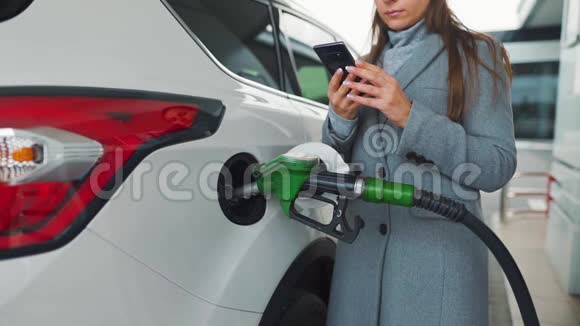 当她的车在加油时她用智能手机慢动作视频的预览图