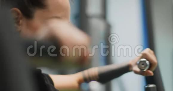 女性在胸部按压机上锻炼女子训练在健身房机器侧视特写慢动作女人压杠视频的预览图
