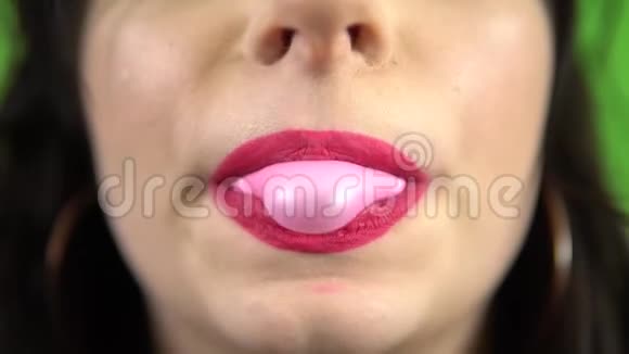 女孩吹泡泡糖粉色口红绿色屏幕上的口香糖糖果视频的预览图