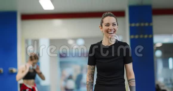 女人在健身房锻炼时休息疲惫的女人在健身休息时放松和微笑前景中景视频的预览图