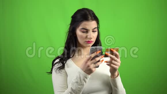 伤心的女人把借记卡的细节放在智能手机网上交易上视频的预览图