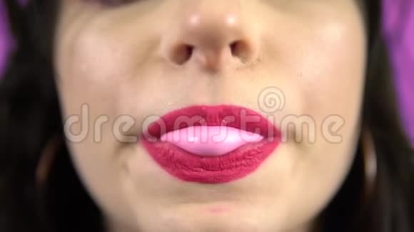 年轻女子吹泡泡糖微笑粉红口红嘴巴紧闭肖像视频的预览图