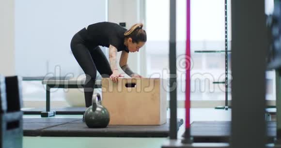 在健身房准备跳箱的女人女人的腿训练前视图女士慢动作健身有氧运动妇女视频的预览图