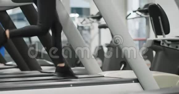 年轻女子在健身房跑步机上跑步后景健身中心女子训练女性锻炼有氧运动视频的预览图