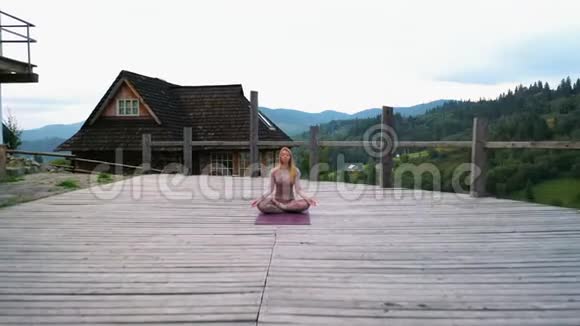 一个女人早上在一个新空气的露台上练习瑜伽视频的预览图