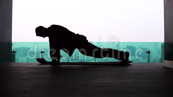 一个男人在大都市背景下的瑜伽姿势的剪影视频的预览图