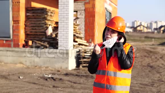 女施工人员穿工作服在施工区域上戴医用口罩视频的预览图