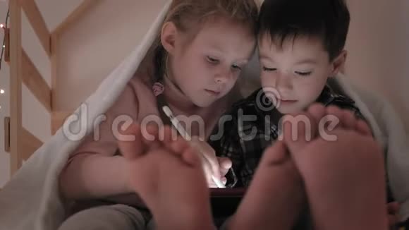 儿童躺在床上使用平板电脑视频的预览图