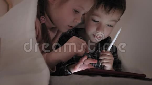 儿童躺在床上使用平板电脑视频的预览图
