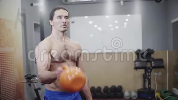 有着美丽肌肉的男人健美运动员训练二头肌和肩部视频的预览图