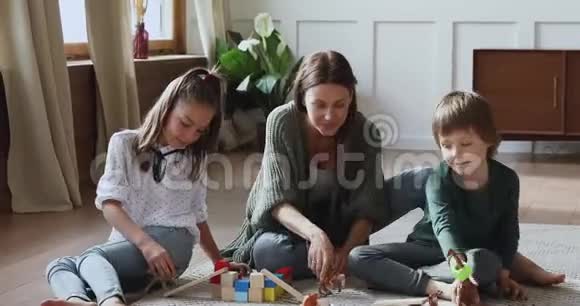 可爱的妈妈在地板上和孩子们一起玩玩具视频的预览图