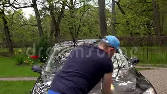 人洗干净自己车前玻璃外带泡沫海绵4K视频的预览图