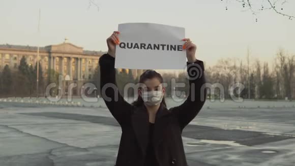 街上戴防护面具的女人拿着检疫海报冠状病毒COVID19视频的预览图