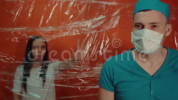 年轻女子伸手去看医生被迫与冠状病毒隔离戴着医疗面具的人隔离了他的病人视频的预览图