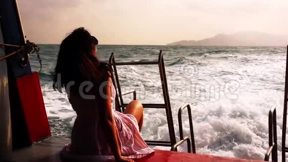 戴太阳镜的年轻女子坐在船上放松视频的预览图