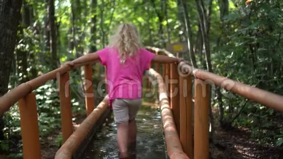 光脚小孩涉水冷水健康小路可爱的5岁女孩视频的预览图