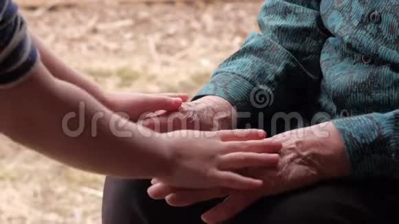 手拉手老妇人牵着她年轻的孙子的手同情代际联系关怀和感情视频的预览图