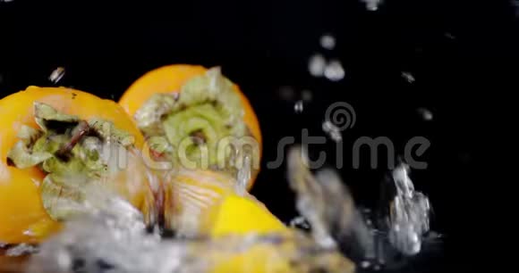 新鲜的柿子切片落在水溅上视频的预览图